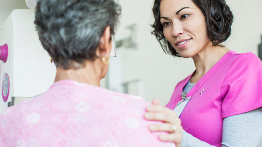 Imaging technician with patient during mammogram appointment