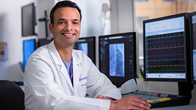 Dr. Akinapelli sitting in front of computer